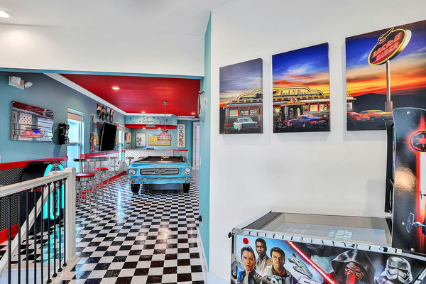 The second-floor recreation room features a pool table, Star Wars digital pinball, Arcade1Up Infinity Gaming Table, full-sized Bluetooth jukebox, and a 65-inch TV