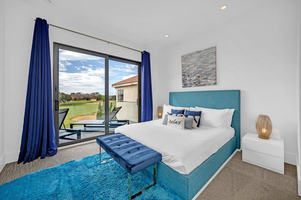 This bedroom features a king-sized bed and access to the private balcony