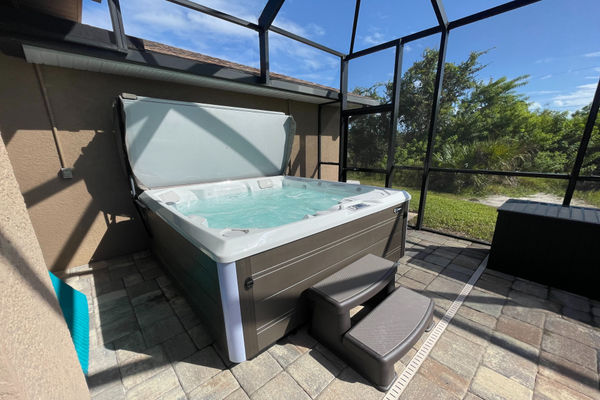 Hot tub overlooking the sparkling pool and canal