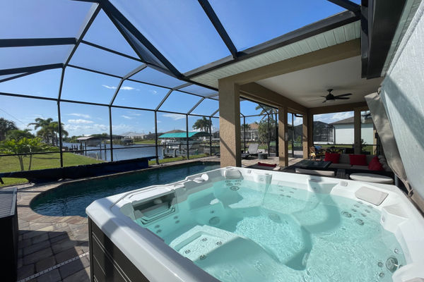 Hot tub overlooking the sparkling pool and canal