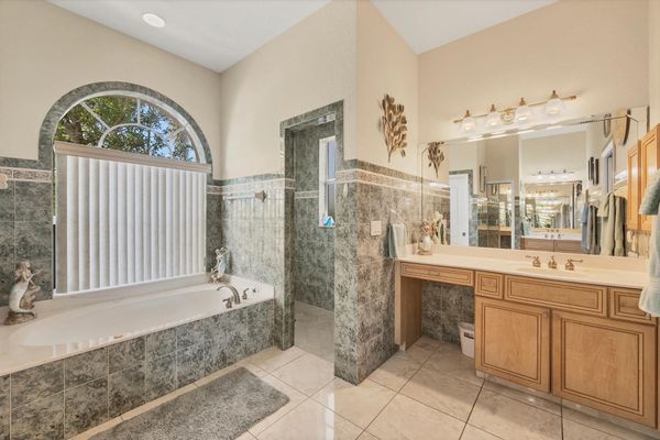 Primary ensuite with walk-in shower, soaking tub, and double vanities