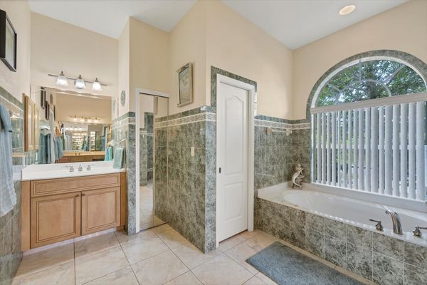 Primary ensuite with walk-in shower, soaking tub, and double vanities