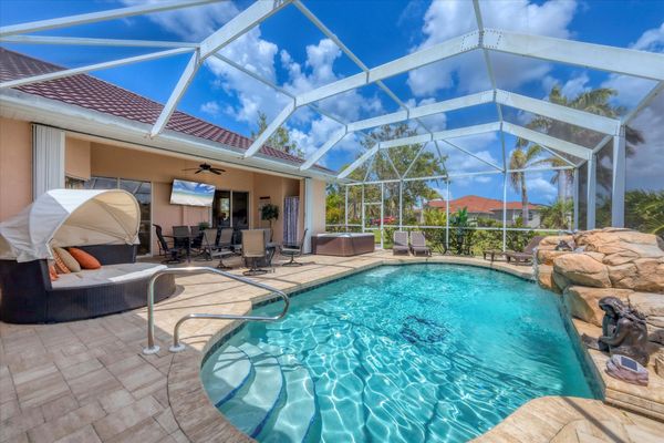 Large lanai with lots of seating, outdoor dining, hot tub, and sparkling pool overlooking the canal
 65' TV