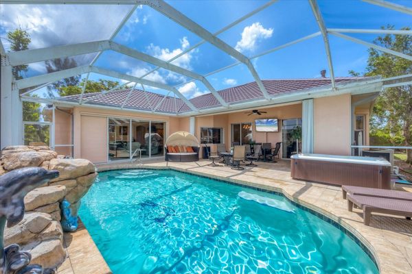 Large lanai with lots of seating, outdoor dining, hot tub, and sparkling pool overlooking the canal
 65' TV