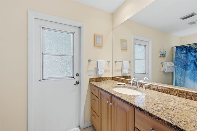 Guest bathroom with shower / tub combo and lanai access