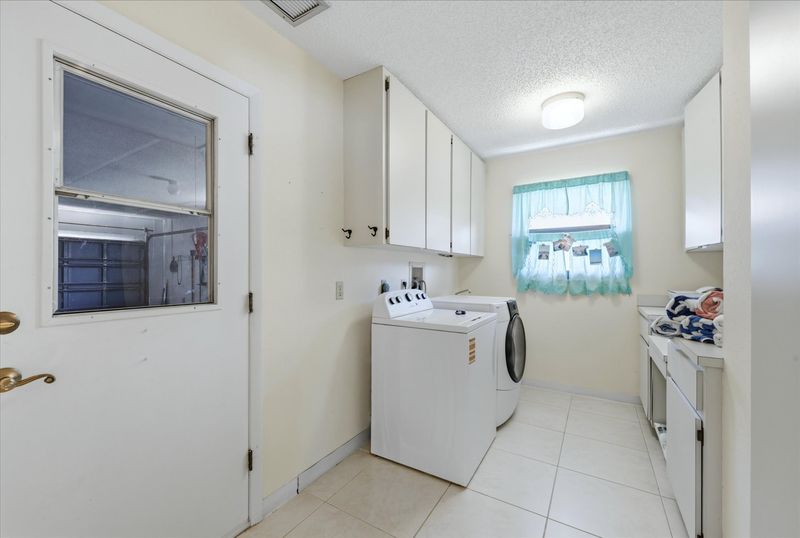 Full size washer and dryer in the laundry room with garage access