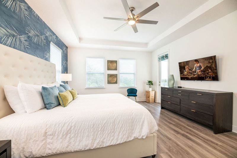 This second-floor master suite has a private balcony overlooking the pool and golf course