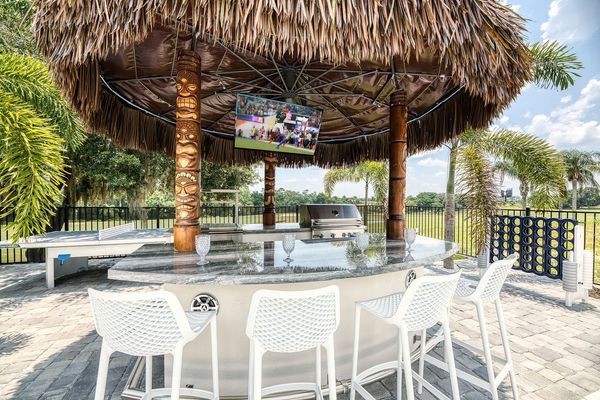 This fun feature elevates the tropical oasis experience with a wine cooler, a mini-fridge, and bar seating while enjoying your favorite show on the T.V