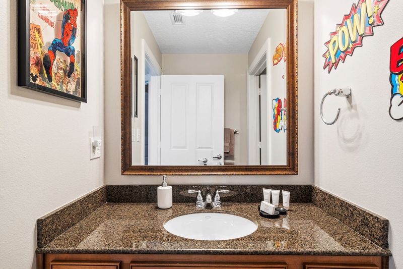 The two themed bedrooms have access to a fun superhero-inspired bathroom with combined tub/shower