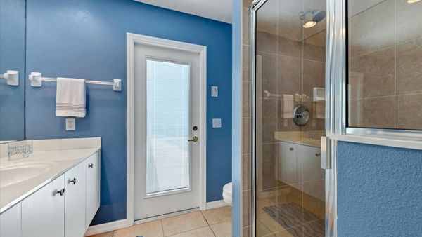 Guest bathroom in hallway leads to lanai area outside