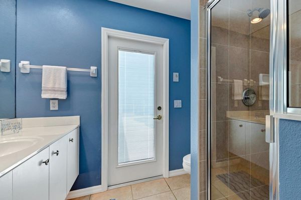 Guest bathroom in hallway leads to lanai area outside