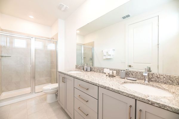 The en suite bathroom has a dual vanity and walk-in shower