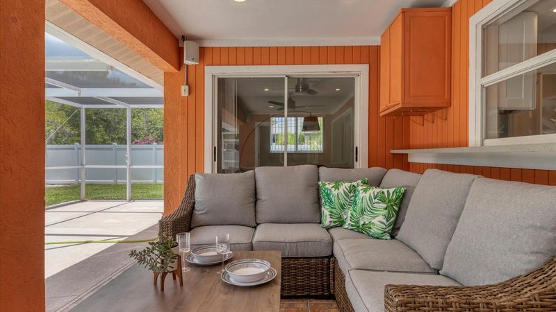 Comfortable outdoor seating space overlooking the pool and private backyard