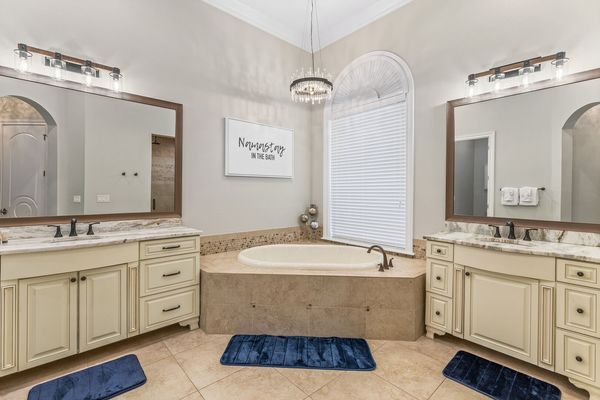 The master en-suite bathroom features his and hers vanity, garden tub, and walk-in shower