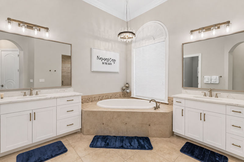 The master en-suite bathroom features his and hers vanity, garden tub, and walk-in shower