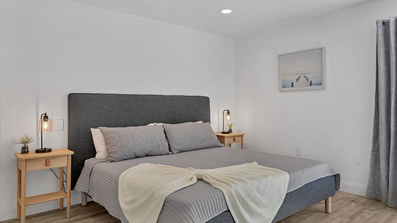 Primary bedroom with king bed, attached bathroom, access to backyard