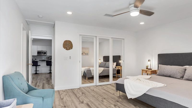 Primary bedroom with king bed, attached bathroom, access to backyard, and 50-inch Smart TV