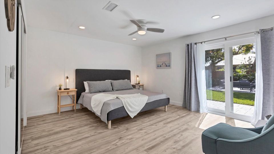 Primary bedroom with king bed, attached bathroom, access to backyard, and 50-inch Smart TV