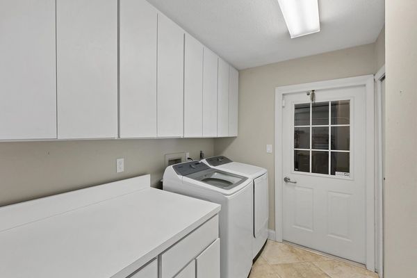 Washer and dryer in laundry room with garage access