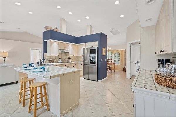 Fully-equipped kitchen overlooking dining room, living room and lanai