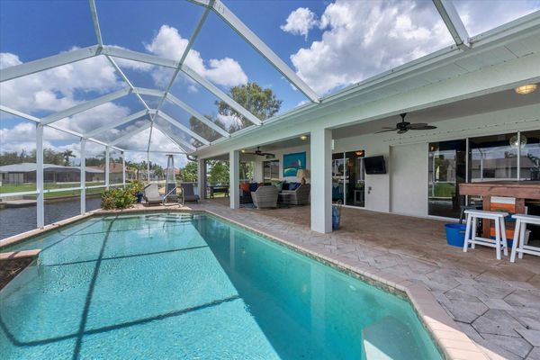 Pool area with tiki bar, loungers, lots of seating and 40" Smart tV