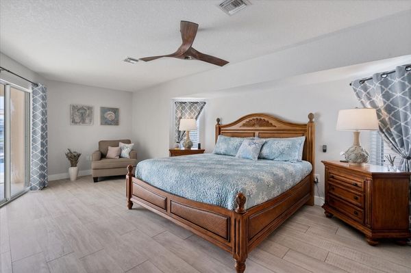 Primary bedroom with king bed, ensuite, 65" Smart TV, and lanai access