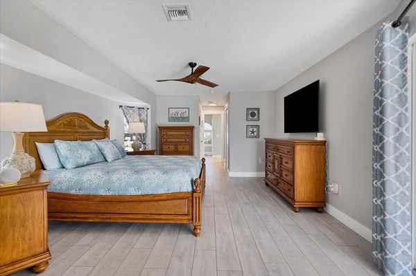 Primary bedroom with king bed, ensuite, 65" Smart TV, and lanai access