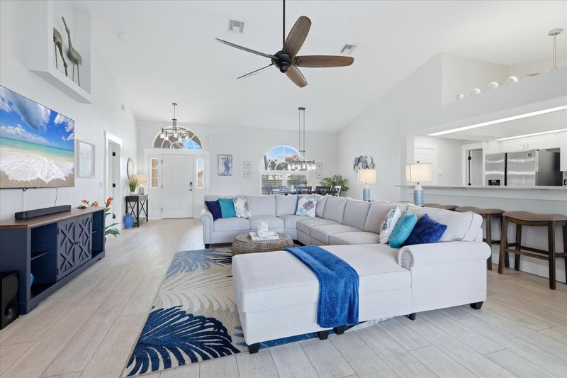 Bright, open living space. Living room features large, comfy sectional sofa and 75" Smart TV