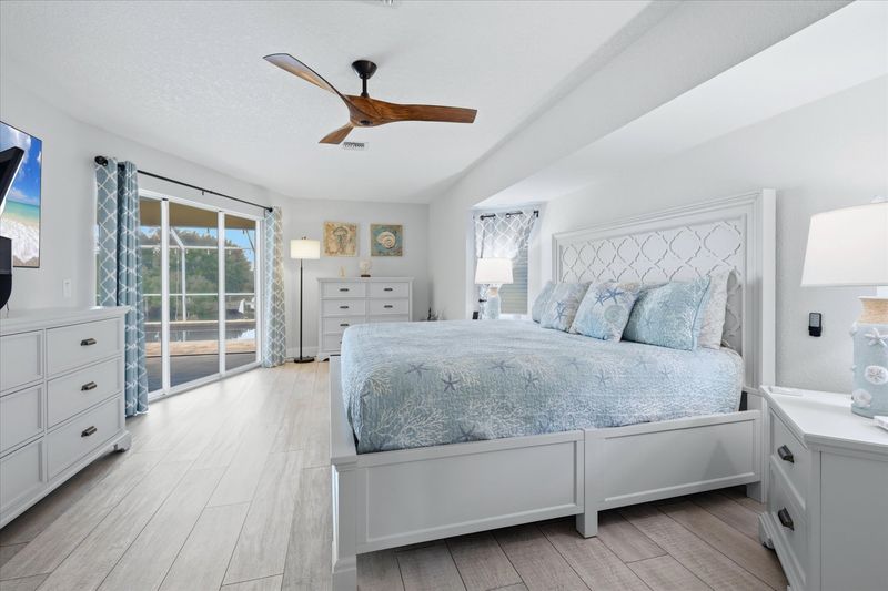 Primary bedroom with king bed, ensuite, 65" Smart TV, and lanai access