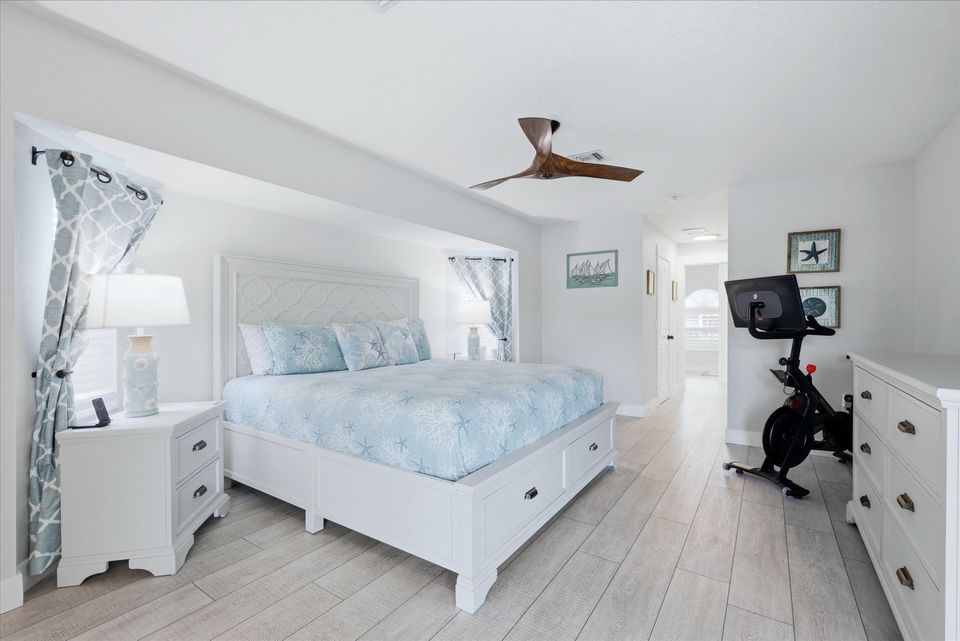 Primary bedroom with king bed, ensuite, 65" Smart TV, and lanai access