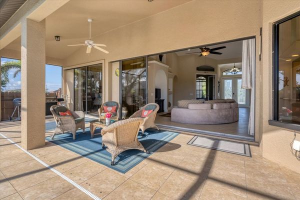 Covered lanai with beuatiful pool and plenty of dining and seating space