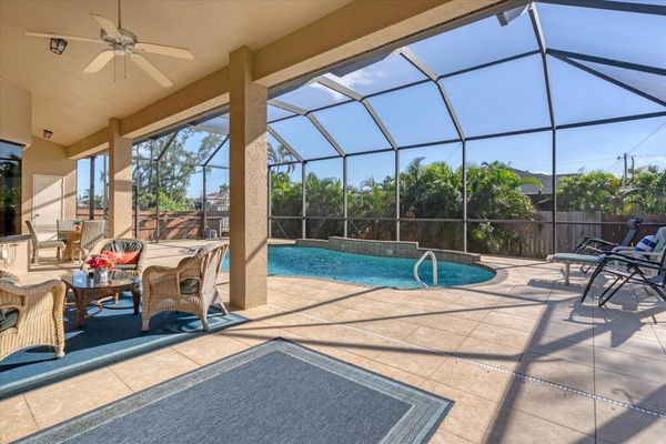 Covered lanai with beuatiful pool and plenty of dining and seating space