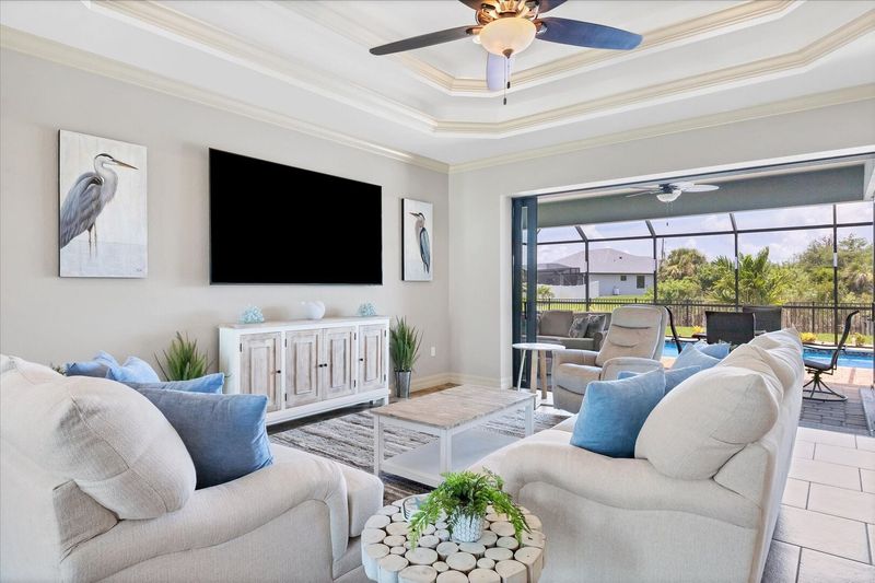Large living room with pool & canal view and 85-inch Smart TV