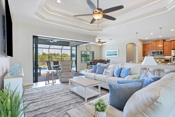 Large living room with pool & canal view and 85-inch Smart TV