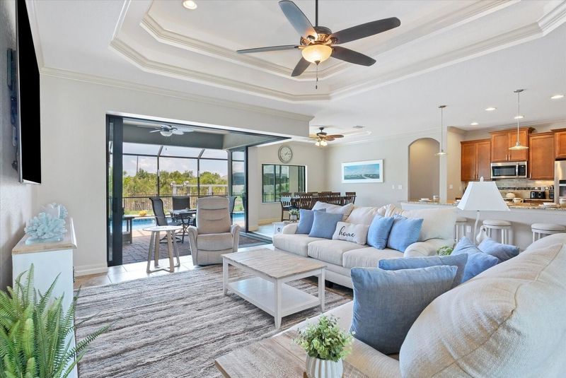 Large living room with pool & canal view and 85-inch Smart TV