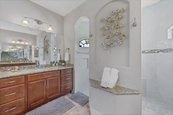 Primary bedroom en suite featuring large walk-in shower & double vanities