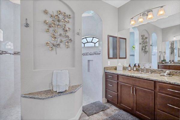 Primary bedroom en suite featuring large walk-in shower & double vanities