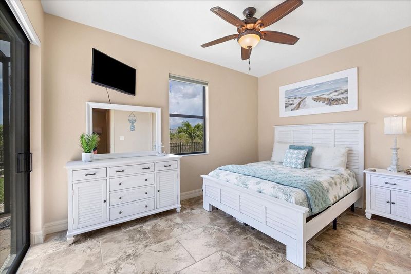 Guest bedroom 1 with queen bed, lanai access and 42-inch Smart TV