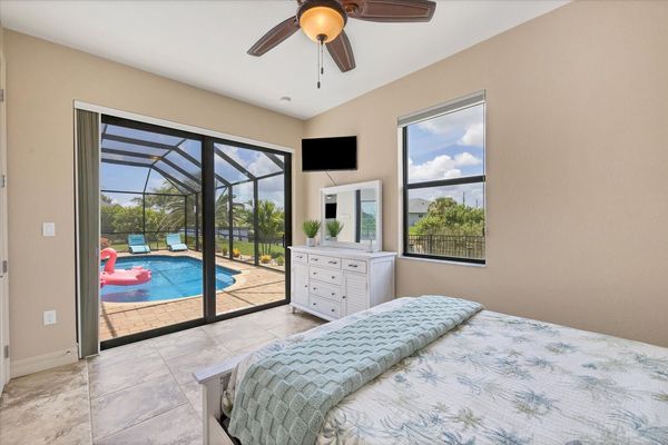 Guest bedroom 1 with queen bed, lanai access and 42-inch Smart TV