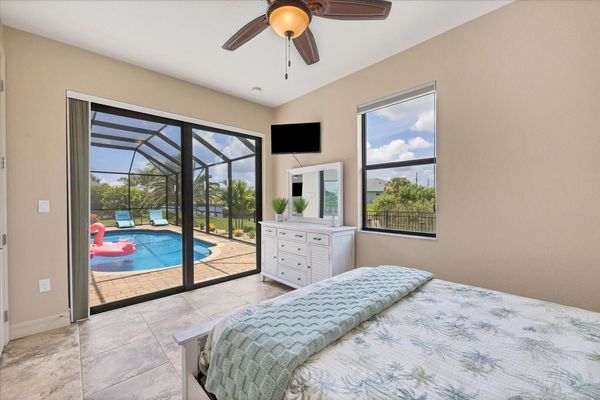 Guest bedroom 1 with queen bed, lanai access and 42-inch Smart TV