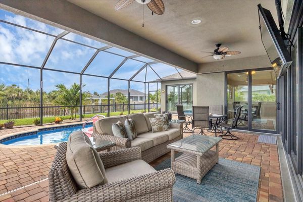 Perfect outdoor space overlooking the pool and canal. Lanai features outdoor kitchen, dining & seating areas, sun loungers, 55-inch Smart TV