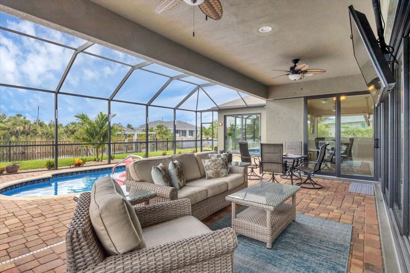 Perfect outdoor space overlooking the pool and canal. Lanai features outdoor kitchen, dining & seating areas, sun loungers, 55-inch Smart TV