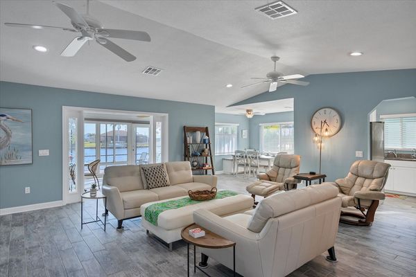 Bright, open living room with view of pool and canal