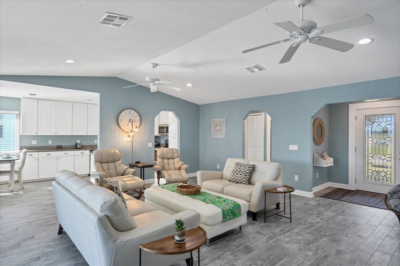 Bright, open living room with view of pool and canal