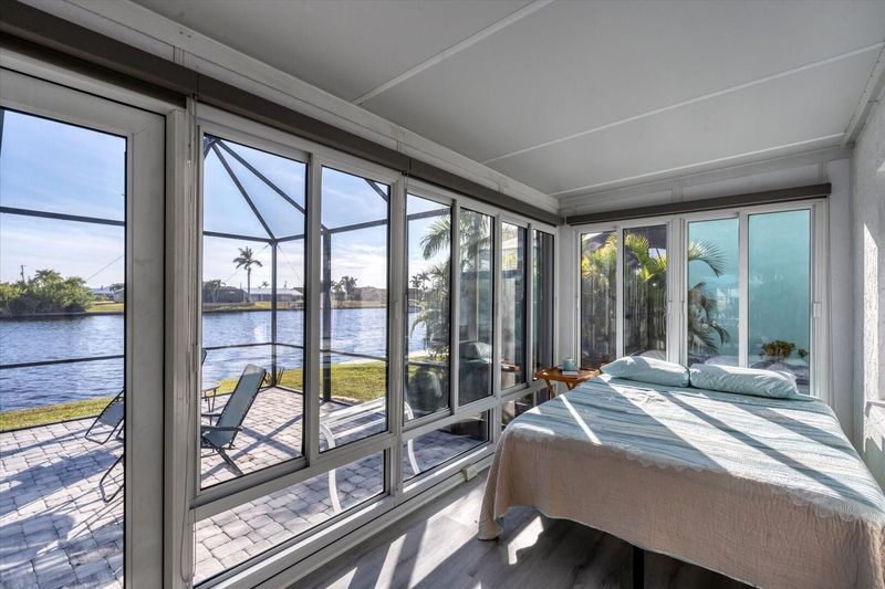 Sunroom nook with queen  bed has a room divider for privacy