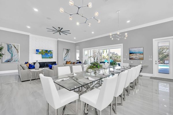 Our well-lit, open-plan dining area features chic white chairs and ample seating for your large group. Enjoy exquisite meals and create unforgettable moments!
