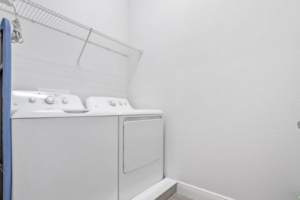 For your convenience, the laundry room is equipped with a top-load washer and dryer, making it easy to keep your clothes clean and fresh during your stay.