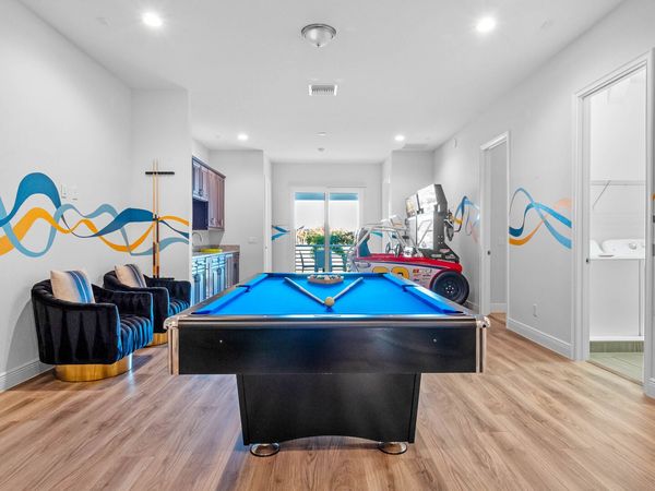 The open space on the second floor is a hub of entertainment, featuring a pool table, poker table, and arcade games, ensuring endless fun for everyone.