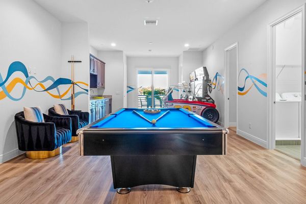 The open space on the second floor is a hub of entertainment, featuring a pool table, poker table, and arcade games, ensuring endless fun for everyone.