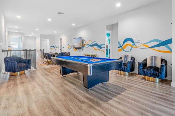 The open space on the second floor is a hub of entertainment, featuring a pool table, poker table, and arcade games, ensuring endless fun for everyone.